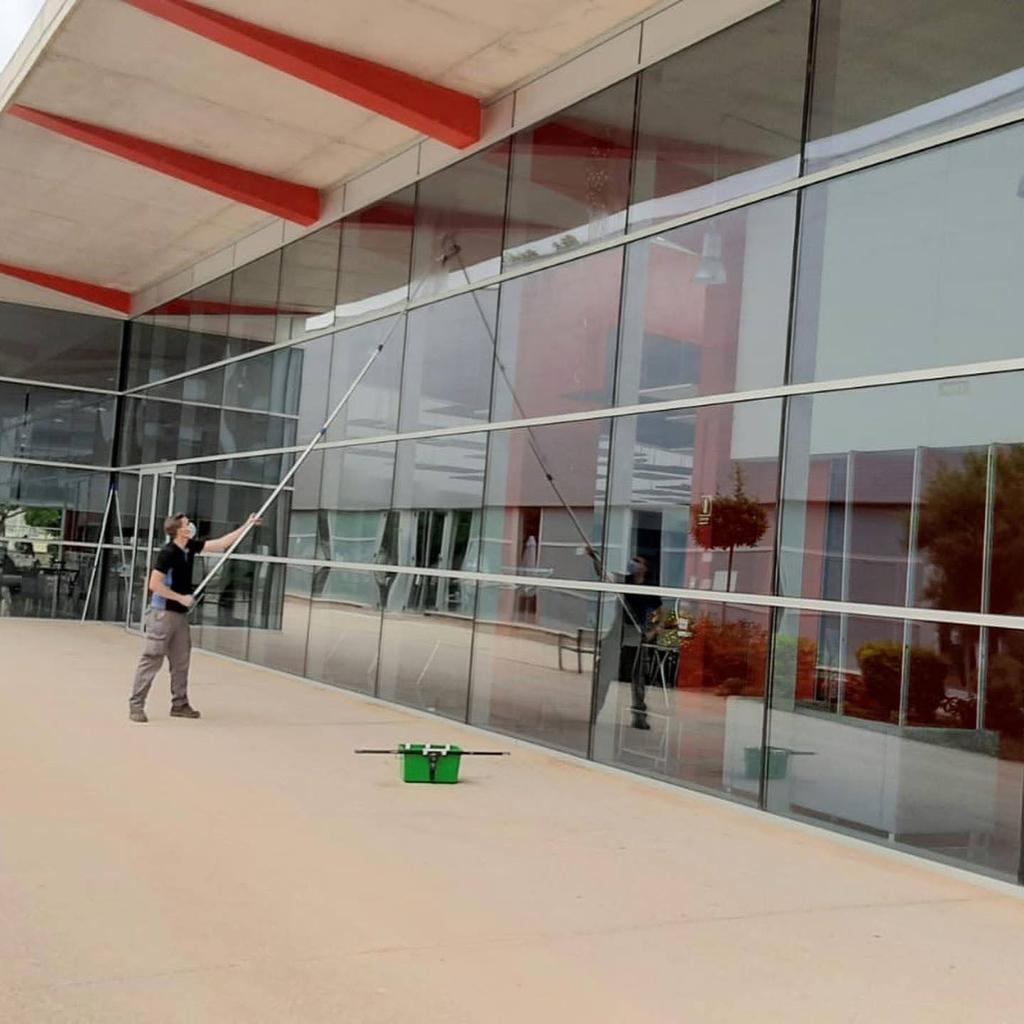 Trabajador de limpiezs bodes trabajando una fachada de cristal